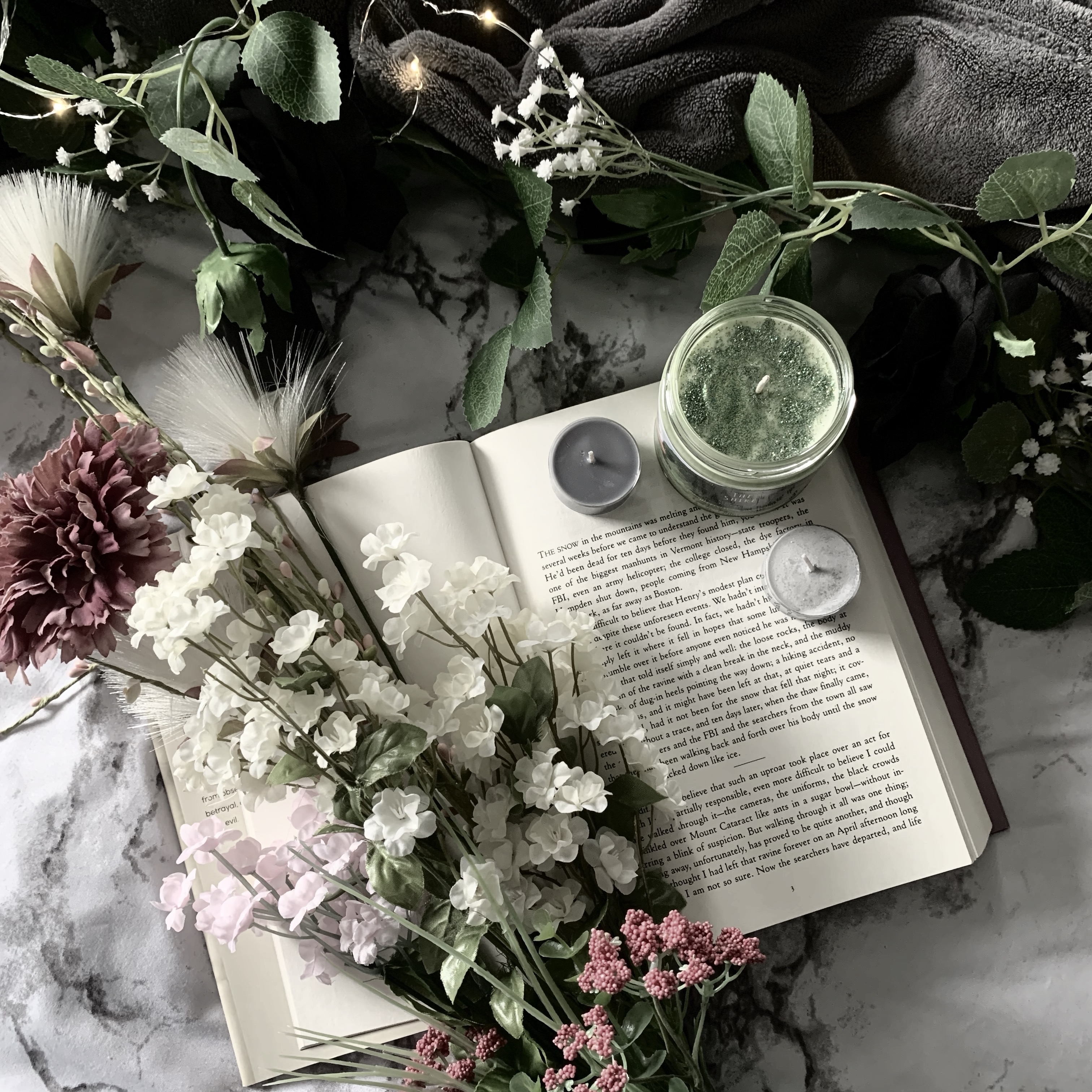 Open book with flowers and candles on it